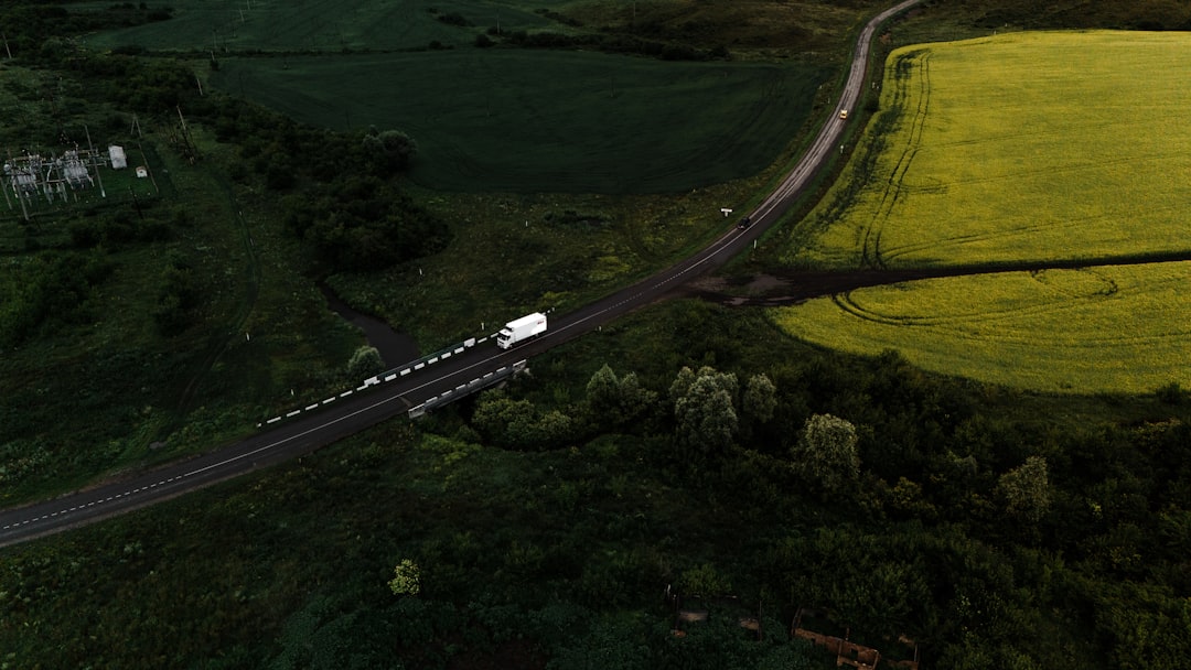 Caminhao Dirigindo Em Uma Estrada Atraves De Campos Verdes YZxY5Eo4e6M