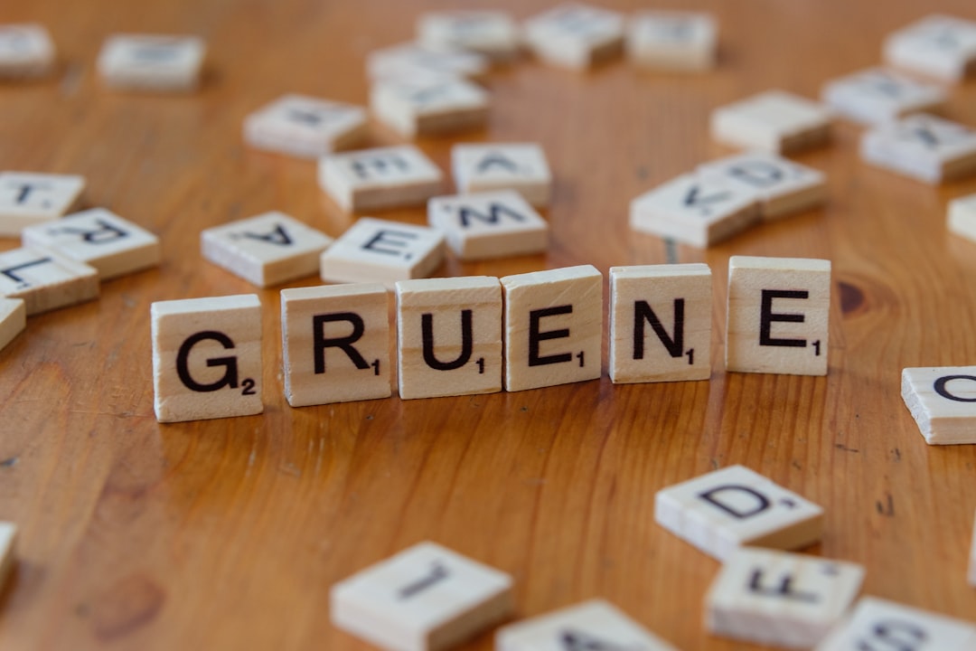 Uma Mesa De Madeira Coberta Com Ladrilhos De Scrabble Soletrando A Palavra Grune FOxSFWtMbR0