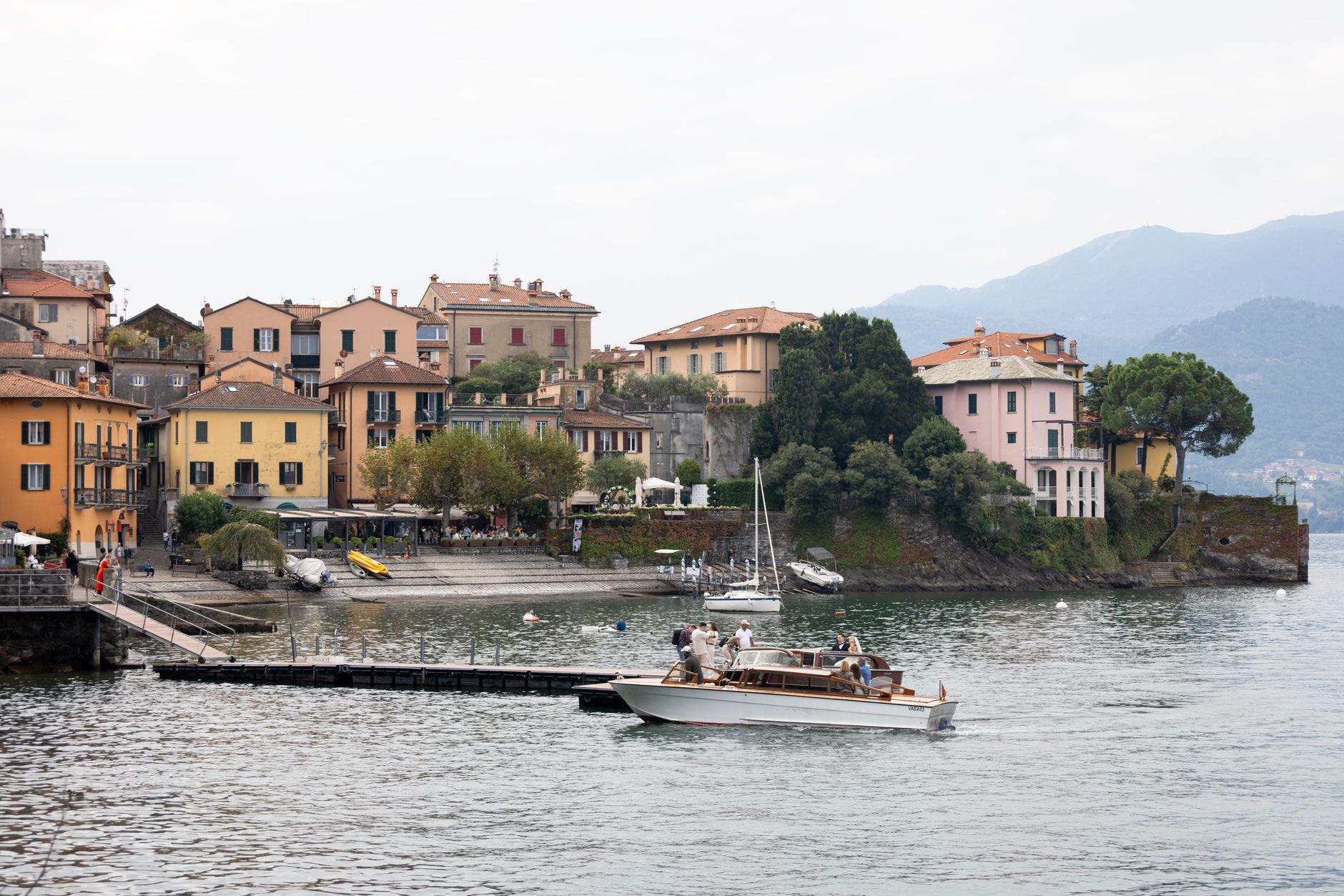 Scenic view of charming village by Lake Como with colorful houses and boats.