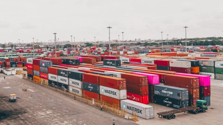 Colorful shipping containers stacked at a bustling port showcasing global trade.