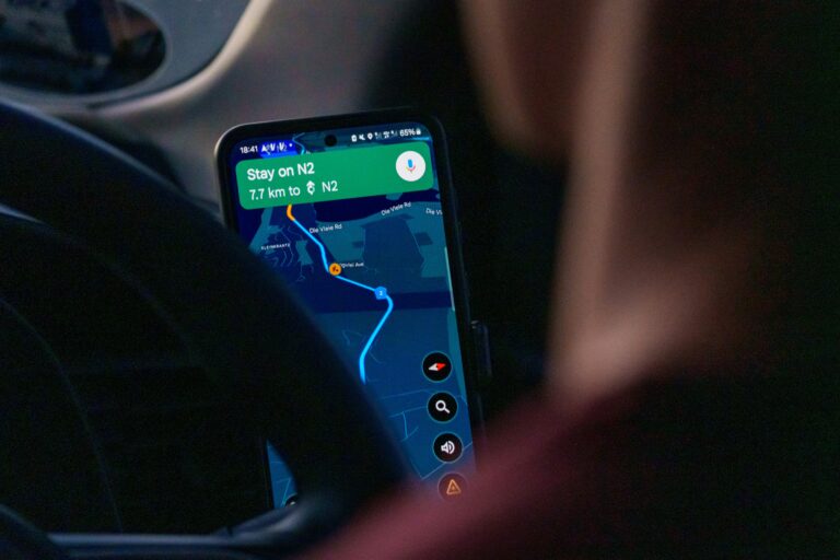 Person using navigation app on smartphone inside car.